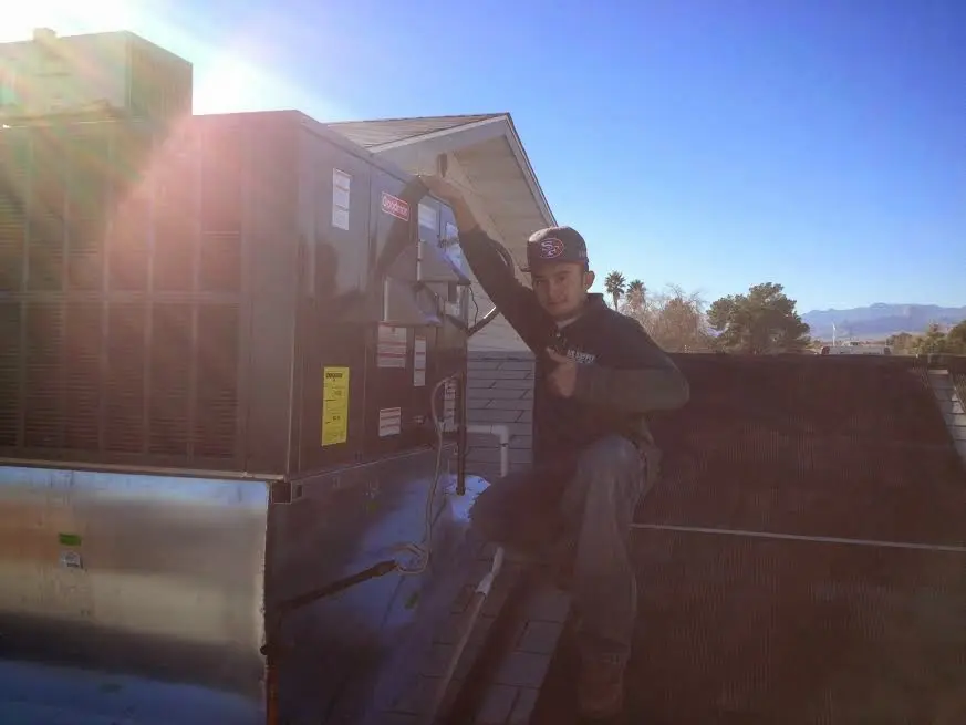 HVAC technician performing HVAC Inspection on a rooftop unit in Shively